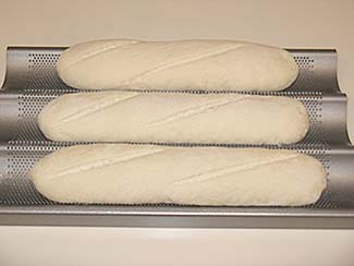Unbaked bread in three-loaf baguette pan.